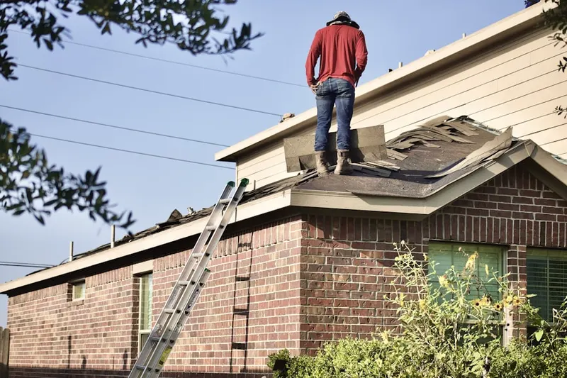 Professional roofer working on a residential roof in Dewey